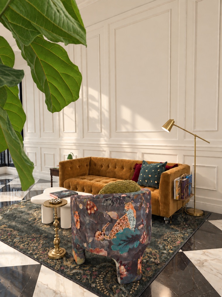 Mustard velvet tufted sofa against white panelling, with fiddle-leaf fig leaves in the foreground, a brass floor lamp, a floral armchair and the black-framed office doors at the edge of the room.